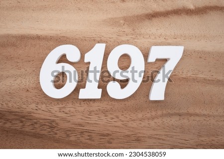 White number 6197 on a brown and light brown wooden background.