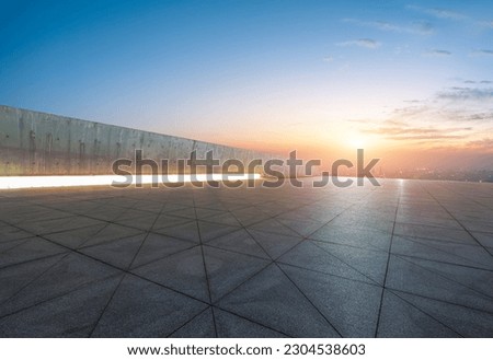 Empty square floor with city skyline at sunset 