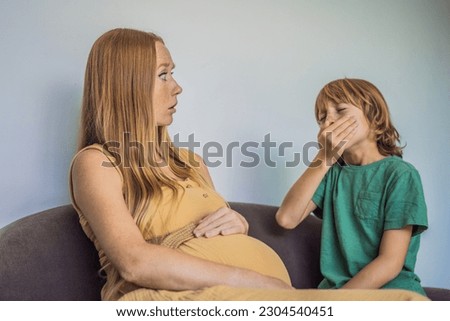 The eldest son came from school and brought the infection. Son sneezes on pregnant mother. Colds and infections in pregnant women Royalty-Free Stock Photo #2304540451