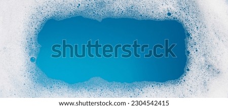 Detergent foam bubble on water. Blue background, Soap sud Royalty-Free Stock Photo #2304542415