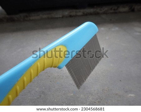 Comb to clean hair from lice. This comb is light blue with a slight yellow line.