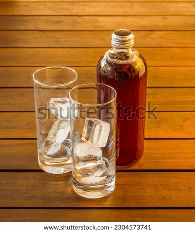 Glasses filled with ice cubes standing in front of a kombucha health drink