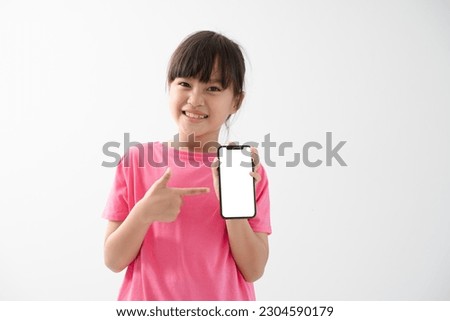 Wow awesome mobile app. Amazed excited cute little boy pointing at cell phone and looking at camera with shocked face, child surprised by telephone, online service. indoor studio shot white background