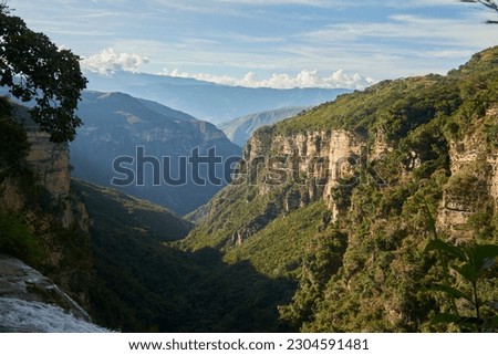 Spectacular mountain scenery, view from the top of the Manchego waterfall, which falls into the Chicamocha canyon, in Aratoca, Santander, Colombia. Royalty-Free Stock Photo #2304591481