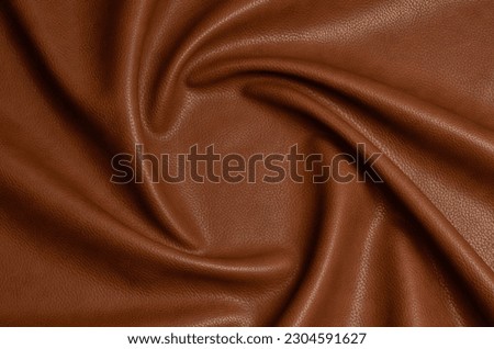 brown artificial leather with waves and folds on PVC base Royalty-Free Stock Photo #2304591627