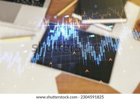 Double exposure of abstract creative financial chart with world map and digital tablet on background, top view, research and strategy concept