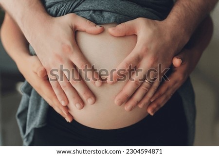 Image of pregnant woman touching her belly with hands.