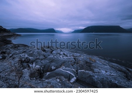 Evening view of the fjords and mountains around Solavågen in Norway. Rocks are in the forground. Copy space, night, dusk, twilight, nordic, north, beautiful, wonderful, mystic