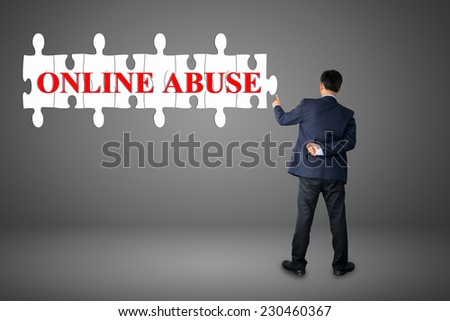 Businessman assembling complete a puzzle an insert word ONLINE ABUSE 