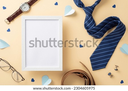 Chic Father's Day layout. Flat lay top view of photo frame, necktie, hearts, watch, accessories, belt, glasses on beige backdrop with an empty space for ad or text