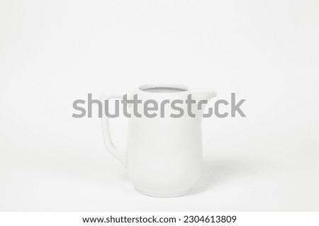 Milk jug on white background. Porcelain sauce boat, pitcher, creamer or ceramic gravy boat. Space for text, for advertising, banner, signboard, menu and printed materials Royalty-Free Stock Photo #2304613809