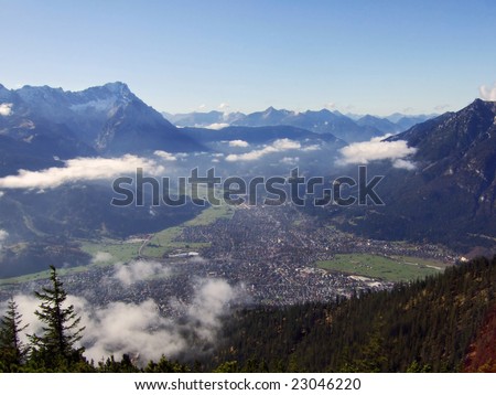 Scenic view in the alps on the bavarian town Garmisch-Partenkirchen from the mountain Wank. In the background on the left is the mountain Zugspitze, Germany's highest peak.
