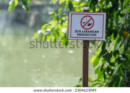 English translation for Malay wordings is "Do not fishing" sign which is located beside the lake.