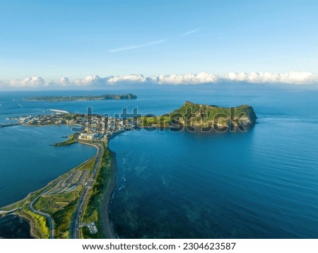 Aerial and panoramic view of road and houses with Gwangchigi beach against Seongsan Ilchulbong Tuff Cone and Udo Island on the sea at Seogwipo-si, Jeju-do, South Korea
 Royalty-Free Stock Photo #2304623587