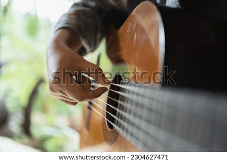 Happy young Woman hands playing acoustic guitar musician  alone compose instrumental song lesson on playing the guitar. Royalty-Free Stock Photo #2304627471