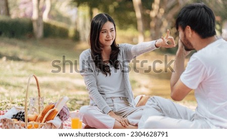 Happy romantic couple in Valentine Day asian couple hold hands for close moment together. happy couple relaxing together with picnic Basket