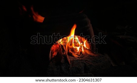 The yellow and red flames of the earthware stove in the dark