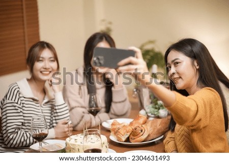Asian sister friends making selfie and smiling with smartphone. celebrating with Birthday cake