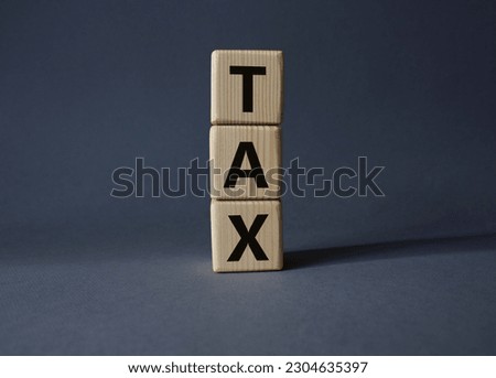 Tax symbol. Wooden cubes with word Tax. Beautiful grey background. Business and Finace and Tax concept. Copy space.