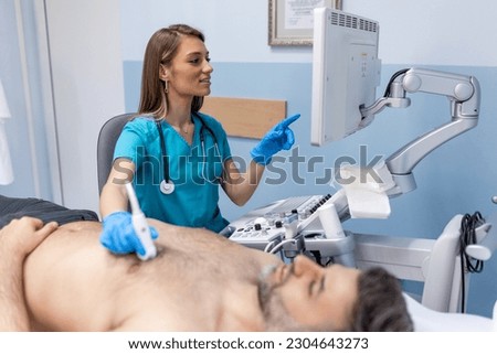 Doctor performs chest ultrasound on man in hospital room. Examination of the heart and vessels concept