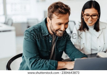 Successful business man using a laptop in a meeting with his colleague. Happy business man playing a slideshow presentation in an office. Royalty-Free Stock Photo #2304643873