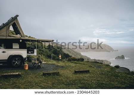 Camping with an overland car on a cliff in Izu Peninsula, beautiful blue sky green grass, and blue sea Royalty-Free Stock Photo #2304645203