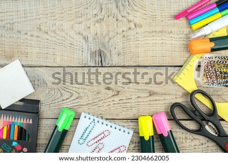Back to school. Scissors, pencils, paper clips, notepad, markers, ruler. School supplies on a wooden table. Top view with copy space