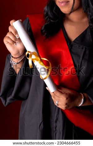 Female student in a graduation photo. End of education degree with graduate diploma. University, tunic with hat