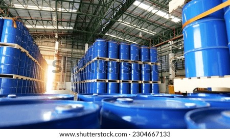 Blue barrel 200 liter chemical drums are stacked on wooden pallets inside the warehouse awaiting delivery. Concept of Chemical industry, petroleum industry and transportation technology Royalty-Free Stock Photo #2304667133