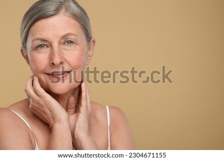 Portrait of senior woman with aging skin on beige background, space for text. Rejuvenation treatment