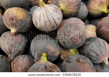 Close-up on a stack of figs for sale on a market stall.