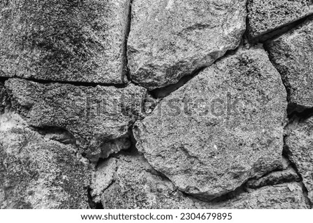Texture of a stone wall. Old castle stone wall. Pattern gray color of modern style design decorative uneven cracked real stone wall surface with cement. Brick texture for wallpaper or background.