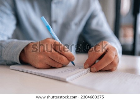 Close-up cropped shot of unrecognizable mature male hand pen sign contract put signature, make investment, taking insurance, writing will testament at desk. Senior aged man writing letter at home.