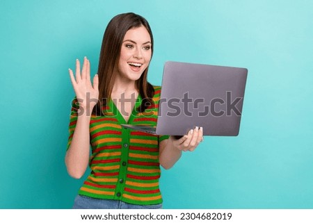 Portrait of cheerful adorable lovely lady use modern netbook chatting speaking friends hi sign gesture isolated on cyan color background