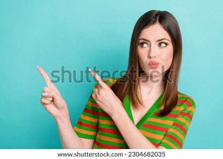 Photo of doubtful unsure woman dressed striped looking pointing two fingers empty space isolated teal color background