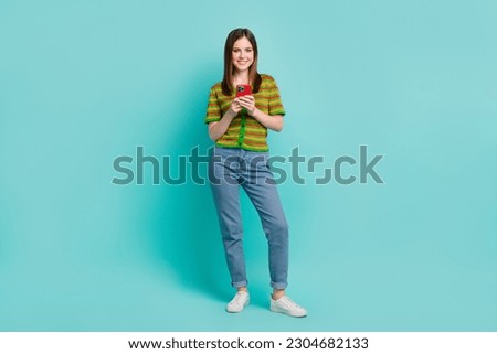 Full length photo of adorable positive lady wear stylish clothes use modern device promote samsung iphone isolated on cyan color background