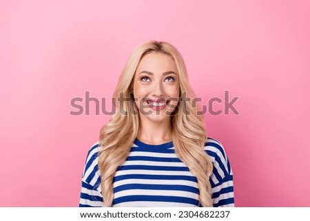 Photo of young happy lady blonde hair wear striped shirt smiling looking up empty space shopping offer isolated on pink color background