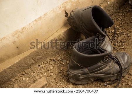 safety boots on muddy and rocky ground