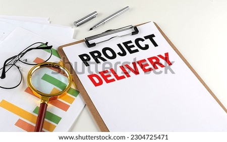 PROJECT DELIVERY text on a clipboard with chart on white background, business concept