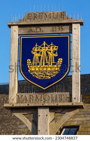 A sign portraying the town crest of Yarmouth, on the beautiful Isle of Wight, UK.  The tower of St. James Church is also pictured.