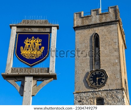 A sign portraying the town crest of Yarmouth, on the beautiful Isle of Wight, UK.  The tower of St. James Church is also pictured.