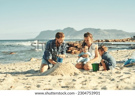 Sandcastle building, parents and children at beach with bonding, love and support. Baby, mom and dad together with kids playing in the sun with mockup space and smile by the ocean and sea with family Royalty-Free Stock Photo #2304753901