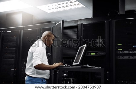 Server room, black man or coding on computer for programming or digital error in data center. Cybersecurity, support or technician typing online for fixing, troubleshooting or software development Royalty-Free Stock Photo #2304753937