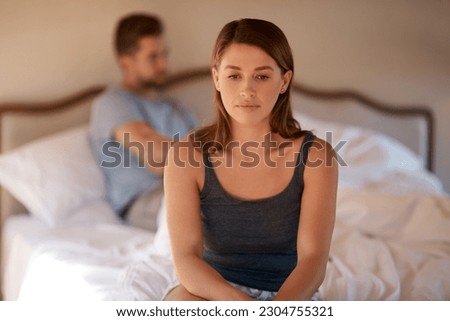 Sad, upset and couple in an argument in their bedroom for divorce or breakup in a modern house. Toxic, mad and face of a woman fighting and in conflict with her boyfriend in bed in their home. Royalty-Free Stock Photo #2304755321