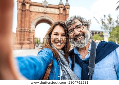 Married couple taking selfie in front of Triumphal Arch in Barcelona, Catalonia, Spain - Husband and wife enjoying romantic moment together at summer holiday in Europe Royalty-Free Stock Photo #2304762531