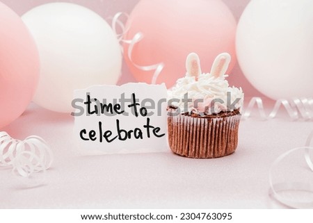 Time to celebrate - card with text and bunny cupcake on pink background with white and rosy air balloons