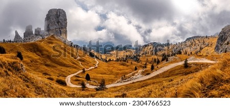 Majestic Cinque Torri in Dolomie Alps during sunset. Stunning panoramic view on Five Towers group, overcast sky and foot road. Amazing nature lanscape background. Dramatic sunrise in the mountains. Royalty-Free Stock Photo #2304766523