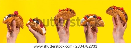 Various sweet taco ice creams. Waffle taco shells with chocolate and vanilla flavour ice cream with different fruits, berry, toppings
