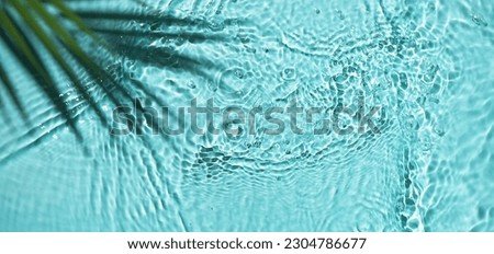 Water background with palm leaf top view. Tropical summer background for design. Travel holiday.