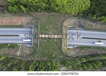 Aerial panorama view of ecoduct or wildlife crossing - vegetation covered bridge over a motorway that allows wildlife to safely cross over,wildlife crossing over busy highway,animal overpass Royalty-Free Stock Photo #2304798761